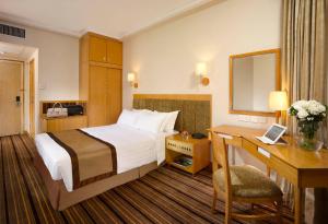 a hotel room with a bed and a desk at The Harbourview - Chinese YMCA of Hong Kong in Hong Kong