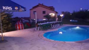 a swimming pool at night with a table and chairs at Villa Miranda in Carrascal de Barregas