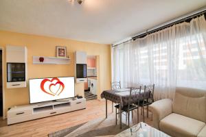 een woonkamer met een flatscreen-tv en een tafel bij Comfortable Homly Apartment in Offenbach