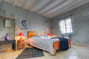 a bedroom with a bed and two lamps and a window at Dar Latigeo in Essaouira