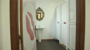 a bathroom with a sink and a mirror on the wall at Hostel 2300 Thomar in Tomar