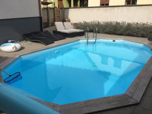 a large swimming pool with blue water in a backyard at LE PIED A TERRE SELESTADIEN in Sélestat +3 photos