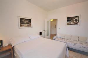 una camera con un grande letto bianco e una scrivania di Holiday Home Santa Margherita Ligure a Santa Margherita Ligure