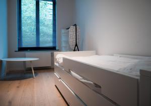 een slaapkamer met een bed, een tafel en een raam bij Smartflats - Stephanie in Brussel