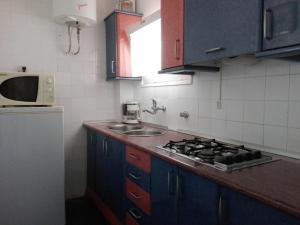 a kitchen with a stove and a sink and a microwave at Zeus Alexis II in Salou