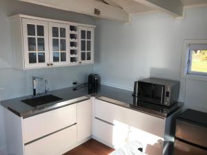 a kitchen with a sink and a microwave at The Boat House in Auckland