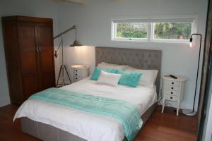 a bedroom with a bed with blue pillows and a window at The Boat House in Auckland