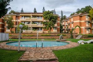 un edificio con piscina in un cortile di Golf Course Apartments a Kampala