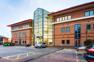 a building with a car parked in front of it at Mondial Apartments at Heathrow in Harmondsworth