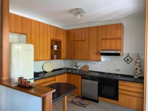 a kitchen with wooden cabinets and a white refrigerator at Il Portico 9 in Bussolengo