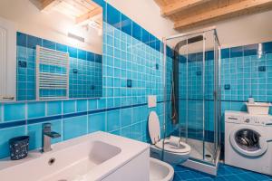 a blue tiled bathroom with a toilet and a sink at Le 3 Sirene in Levanto