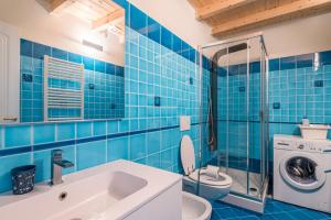 レヴァントにあるLe 3 Sireneの青いタイル張りのバスルーム(トイレ、シンク付)