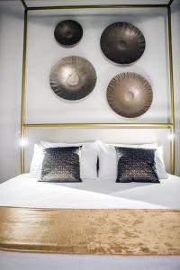 um quarto com uma cama com cabeceira e almofadas em Scene Suites Apartments em Catânia