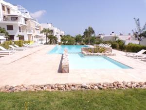 uma grande piscina num resort com cadeiras em 3 Bedroom Luxury Apartment Villamartin em Orihuela