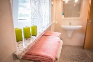 un bagno con candele verdi e asciugamani rosa su un bancone di Agriturismo Trefrutti ad Arco