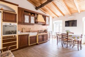 a kitchen with wooden cabinets and a table with chairs at Le 3 Sirene in Levanto