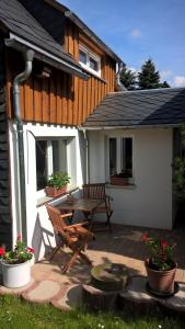 een patio met een tafel en stoelen en een huis bij Ferienhaus Fernblick Altenberg in Kurort Altenberg