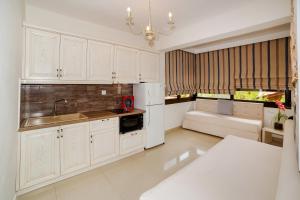 a kitchen with white cabinets and a sink at kassandrinos apartments apostolos in Nikiti