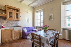 een keuken en eetkamer met een tafel en een paarse bank bij I Delfini in Levanto