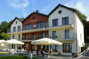 people sitting under umbrellas in front of a building at Klemens in Puck