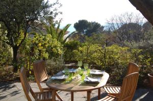 uma mesa de madeira com pratos e copos num pátio em Calanque em Cassis