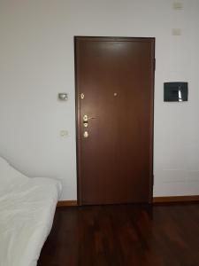 a brown door in a room with a bed at Pisco Home in Milan