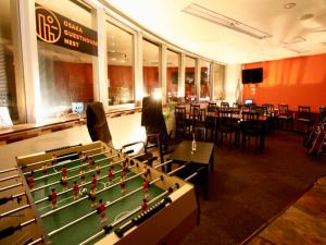 a pool table in a restaurant with tables and chairs at Osaka Guesthouse Nest in Osaka