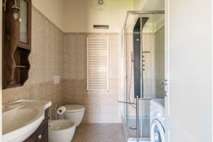 een badkamer met een wastafel, een toilet en een douche bij I Delfini in Levanto +26 foto's