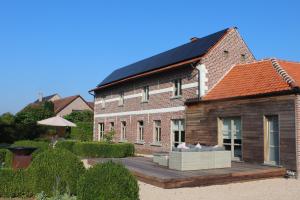 a house with a solar roof on a wooden deck at Mille Étoiles in Moorsel