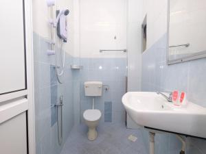 a white bathroom with a toilet and a sink at OYO 44029 Tudor Home Inn in Cameron Highlands