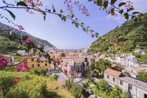 Blick auf eine Stadt von einem Hügel mit rosa Blumen in der Unterkunft Montagnella Relax in Maiori