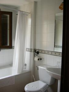 a white bathroom with a toilet and a sink at Hostal Calderon Cuenca in Cuenca +22 photos