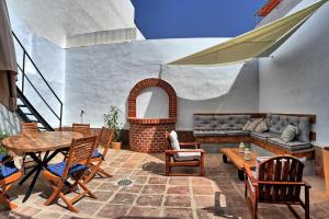 a patio with a table and chairs and a couch at Modern house in Calle Carretas in Nerja