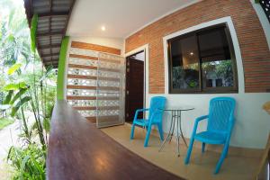 une chambre avec deux chaises bleues et une table dans l'établissement Wandee Bed & Breakfast, à Khao Lak