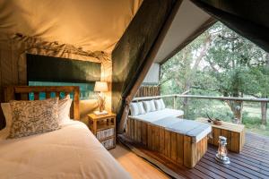 a bedroom with two beds in a tent at Rukiya Safari Camp in Hoedspruit