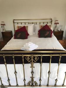 a bed with red and black pillows on it at West End Lodge in Esher