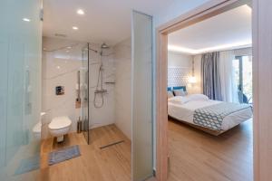 a bedroom with a bed and a bathroom with a shower at Triton Boutique Hotel in Kos Town