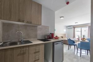 a kitchen with a sink, stove, dishwasher and refrigerator at Paul Marie Hotel Apartments in Ayia Napa