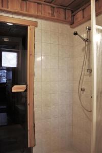 uma casa de banho com um chuveiro e uma porta de vidro em Villa Tunturituuli em Kuusamo