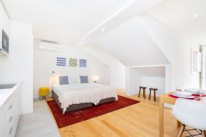um quarto branco com uma cama e uma mesa em Porta do Mar Deluxe Central Apartments em Lisboa