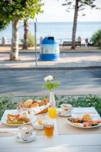 a table with breakfast foods and drinks on it at Triton Boutique Hotel in Kos