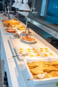 una línea de buffet con huevos y otros productos para el desayuno en Triton Boutique Hotel, en Cos