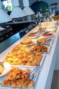 a buffet line with plates of food and pastries at Triton Boutique Hotel in Kos