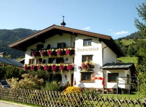 a white building with flowers on it at Pension Stubachblick in Uttendorf