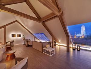 an attic living room with a large window at Sala Ayutthaya in Phra Nakhon Si Ayutthaya