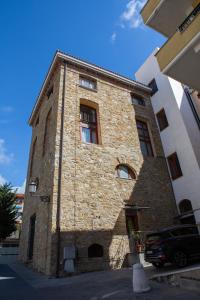 
a large brick building with a clock on the side of it at Casa Trezeni in Santa Maria di Castellabate
