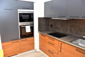 a kitchen with wooden cabinets and a stove top oven at Comfort Apartments by Livingdowntown in Zürich