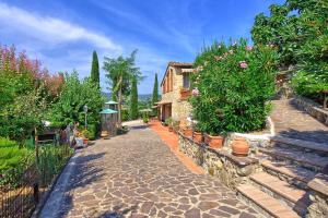 a stone pathway with plants and a house at Poggiluglio by PosarelliVillas in San Gimignano