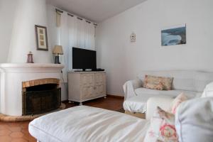 a living room with a couch and a fireplace at Beach House at Praia da Luz in Luz