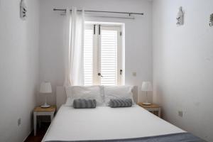 a white bed in a room with a window at Beach House at Praia da Luz in Luz